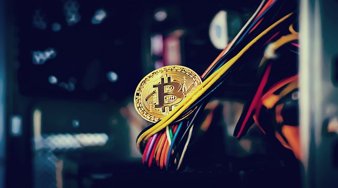 holding golden Bitcoin on Bitcoin mining background